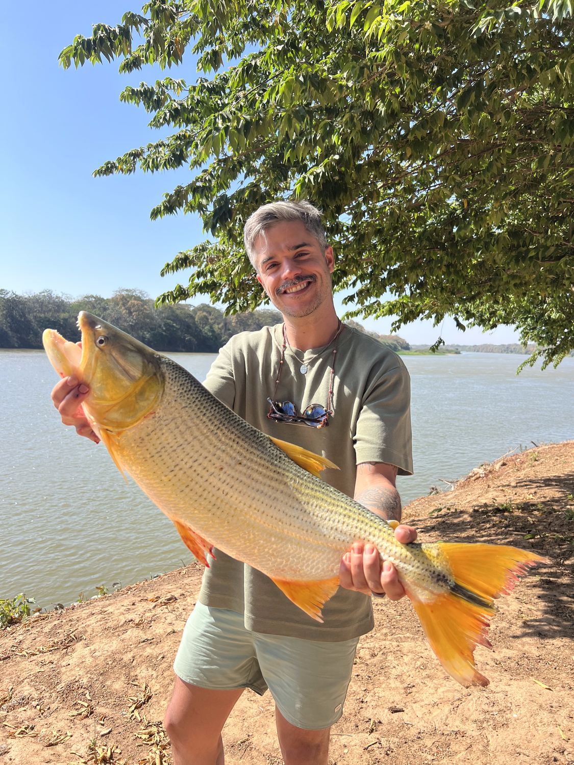 Gentil Nascimento segurando um peixe durante gravação